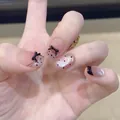 Detail of cat eye press-on nails with 3D black bows, polka dots and French tips - Standard Type / Purple Dot Bow Style (BY2235)