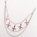 Detailed macro view of triple-layered silver hip chain with red enamel cross charms - Red