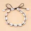 Dettaglio di collana con conchiglie cowrie e cordino intrecciato nero regolabile - Cordino Nero Sciolto / Nero
