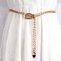 Elegante cintura a catena dorata con fibbia quadrata e pendente su un abito bianco - Oro