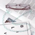 Close-up of light blue acrylic glasses chain with metal lobster clasp on purple frame - Light Blue