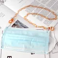 Amber acrylic mask chain with lobster clasps and silicone loops shown on a blue mask - Orange