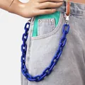 Detail van een dikke donkerblauwe acryl broekketting met metalen sluiting op een jeans - Blauw
