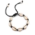 Détail d'un bracelet en coquillages fait main avec huit cauris blancs sur un cordon noir tressé - Corde Noire avec Turquoise