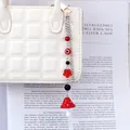 Detail of mushroom and evil eye charms on a stylish silver chain for handbags - Red