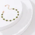 Bracelet marguerite doré minimaliste avec pétales verts sur des supports en pierre - Bracelet Fleur Verte