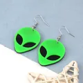 Detail shot of neon green acrylic alien earrings with black eyes and silver hooks - Green