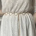 Chaîne de taille dorée à motifs cœurs et lune sur une robe en dentelle blanche - Chaîne de Taille Cœur Or