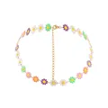 Close-up of colorful enamel daisy charms on a delicate gold alloy chain necklace - Colorful