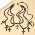 Macro detail of punk black multi-layer chain with vintage cross pendants and matte finish - Black