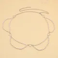 Detail einer mehrlagigen silbernen Taillenkette mit Kunstperlen und Herzanhängern - Silber