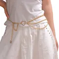 Detail of layered gold body chain featuring heart connector and sun pendant on white dress - Gold Heart Moon Waist Chain