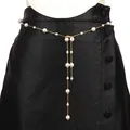 Detail of gold metal waist chain with white faux pearls and cascading fringe tassels - Gold