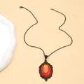 Close-up of gothic orange crystal pendant with vintage black metal filigree detailing - Red