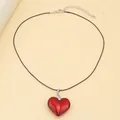 Detail of red glass heart pendant with black cord strap and silver lobster clasp closure - Red