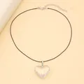 Detail shot of a minimalist heart-shaped glass pendant with adjustable black cord strap - White