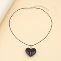 Detail of a minimalist black heart pendant with smooth finish and adjustable wax cord - Black