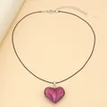Detail view of purple glass heart pendant with black cord and adjustable metal clasp - Purple