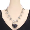 Dettaglio della collana punk a catena argento con punte metalliche e ciondolo a cuore nero deciso - Nero