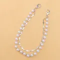 Detail of layered silver metal chain with white pearls and small cross charms - Cross Pearl Style