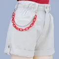 Detail of red acrylic and silver bead chains on white denim shorts waist hook - Red