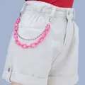 Detail of neon pink acrylic chain and silver bead link on white denim shorts - Rose Red