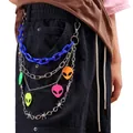 Detail of layered waist chains with blue plastic links and colorful alien charms on black pants - Blue