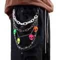 Detail of multi-layer punk pants chain with colorful alien pendants and barbed wire link - White