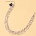 Macro detail of multi-layered silver metal shoe chains with black pixel heart charm - Silver