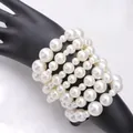 Dettaglio del set di braccialetti di perle bianche multistrato su un modello di mano - Bracciale di Perle Multistrato