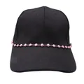 Detail of pink evil eye bead chain with gold metal links on a black baseball cap - Pink
