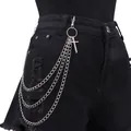 Dettaglio catena per pantaloni argento multistrato con pendente a croce su jeans neri - Stile Croce a Tre Strati Argento