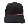 Close-up of red evil eye beaded chain on black twill cotton baseball cap decorative detail - Red