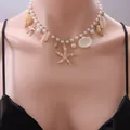Detail of bohemian necklace with gold starfish, shells and white pearls on a model - Pearl Starfish Conch Necklace