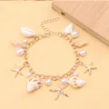 Detail of bohemian gold bracelet with sea shell, starfish charms and faux pearls - Starfish Conch Bracelet