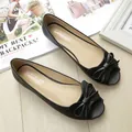 Elegant black peep-toe flat shoes with a decorative bow on light wood background - EU 38 / Black