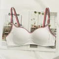 White ribbed sports bra with red and black striped straps on artistic background - S / White
