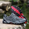 Men's dark grey trekking shoes with red accents and breathable mesh in outdoor setting - EU 39 / Gray