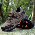 Scarpe da trekking kaki e nero con dettagli arancioni su roccia naturale - EU 39 / Marrone