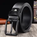 Men's black leather belt featuring a matte black metal pin buckle on a wooden surface - 105cm / Black