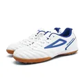 White low-top soccer cleats with blue accents and durable brown rubber turf soles - EU 36 / White