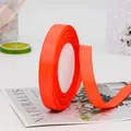 Bright orange 1.5cm grosgrain ribbon roll with distinct ribbed texture for gift wrapping - Fluorescent Red
