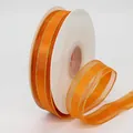 Orange organza ribbon with gold metallic edges on a spool for DIY crafts and decor - Orange