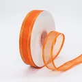 Vibrant orange organza ribbon with gold metallic edges on a white spool for DIY crafts - Orange Gold Edge