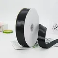 Elegant black satin ribbon roll on a marble gift box with fresh decorative accents - Medium Long Paper Core Roll (BH-44)