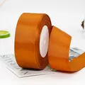 Orange bronze grosgrain ribbon roll with ribbed texture on white foam core for DIY crafts - 22 Meters / Brown