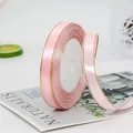 Light pink satin ribbon with gold edges on roll for gift wrapping and DIY crafts - Pink