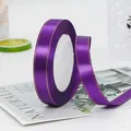 Lila Satinband mit Goldkante auf einer weißen Spule für Geschenkverpackungen und Basteln - Lila