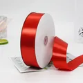 Vibrant red satin ribbon roll on white spool for gift wrapping and festive decor - Extra Wide Long Red Ribbon