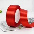 Vibrant red satin ribbon roll for gift wrapping and wedding decor on a white surface - Extra Wide Standard Bright Red Ribbon